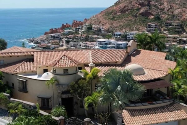 Hilltop villa with terracotta tile roof overlooking coastal town and blue ocean
